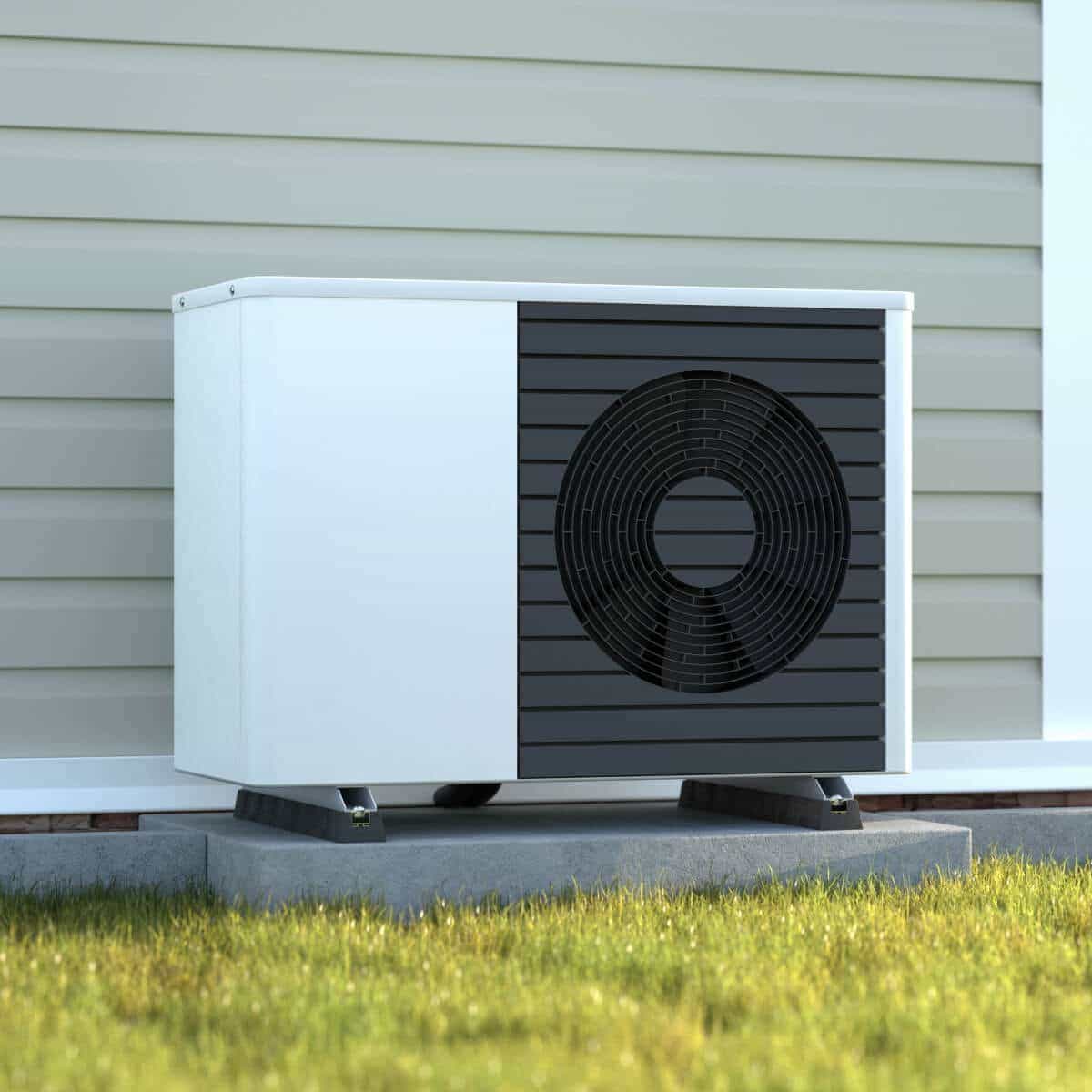 Pompe à chaleur air-eau posée sur dalle béton devant une maison blanche moderne avec jardin — dimensionnement correct