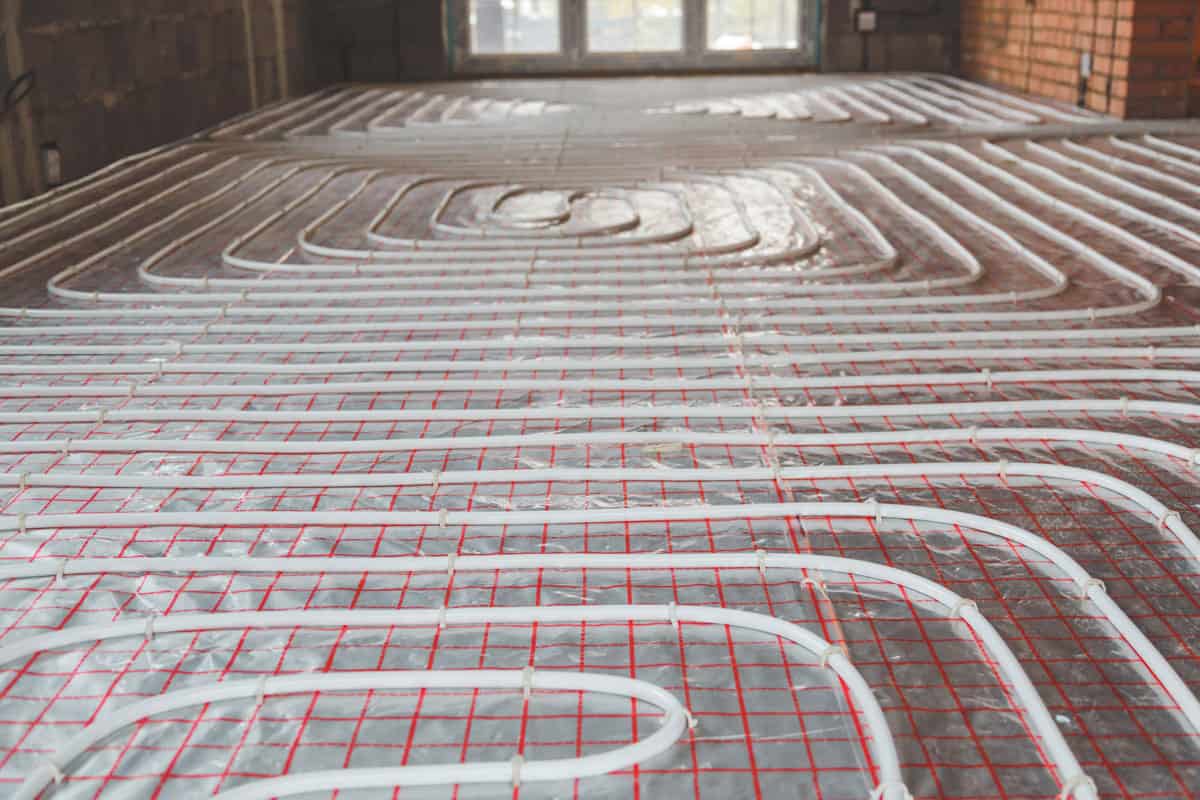 Circuit de tuyaux en serpentin d'un plancher chauffant hydraulique posé sur isolant réfléchissant — avant coulée de la chape